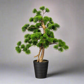 Zöld színű, mű fenyő bonsai fa, fekete színű műanyag cserépben.